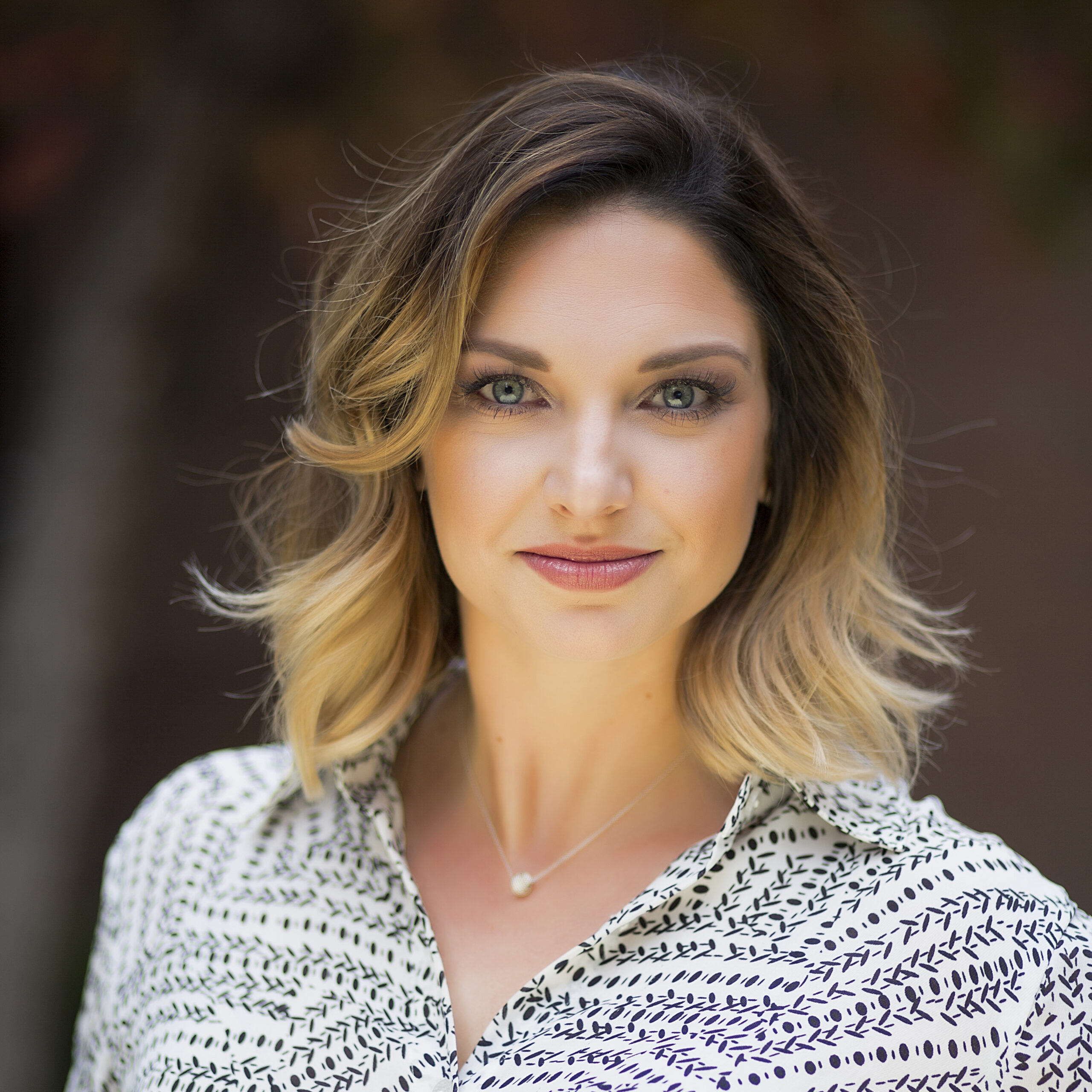 Portrait of Meghan Rose with a warm brown background.